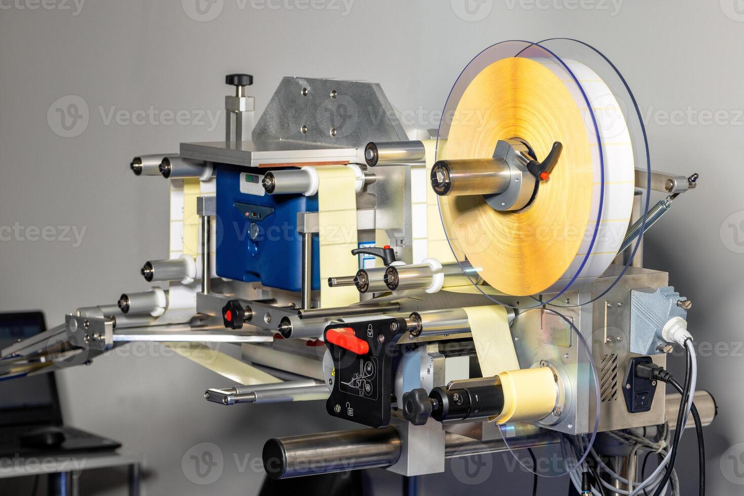 Applicator of self-adhesive labels in a drum roll. photo