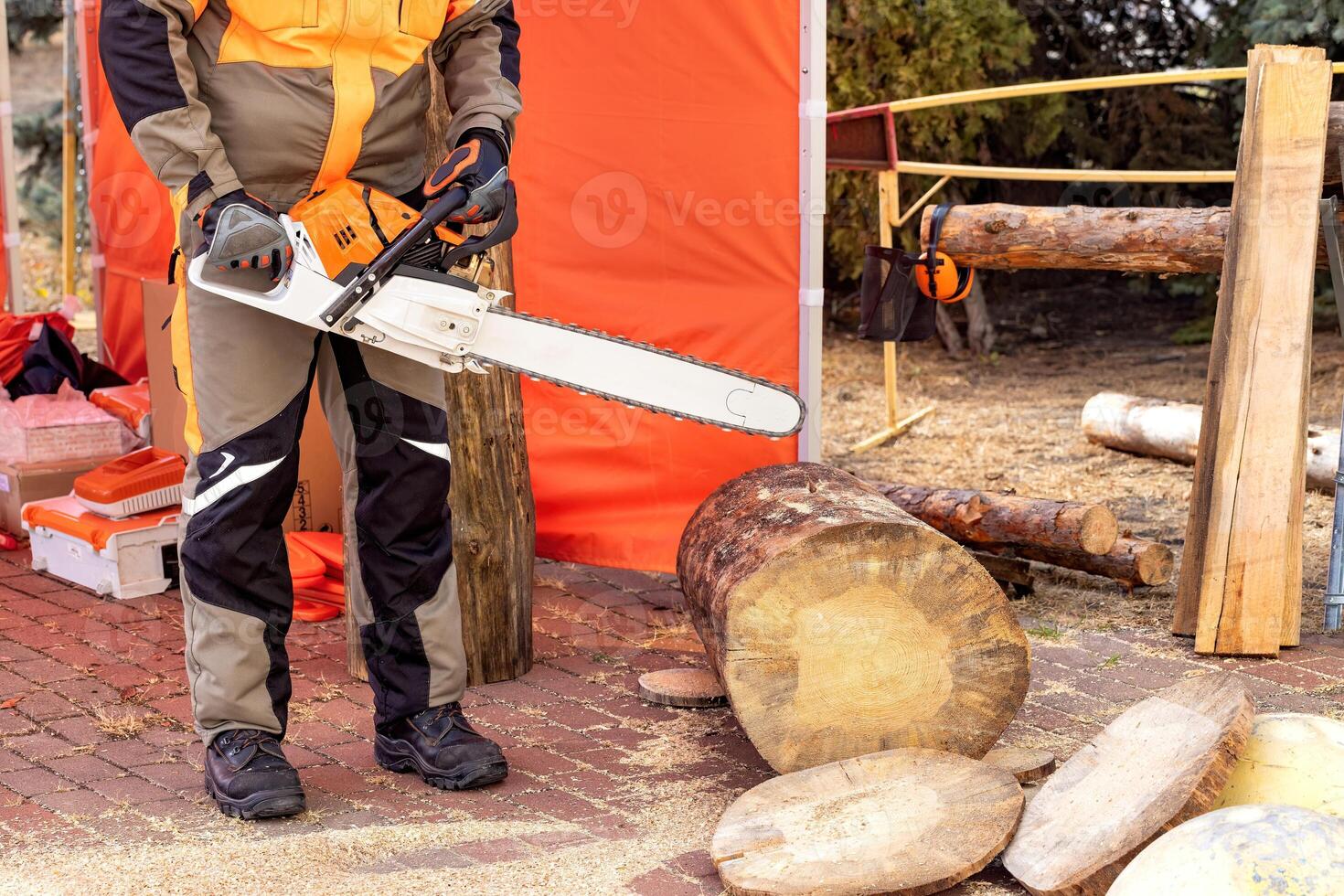 Chainsaw in action at a wood processing site under warm afternoon light photo