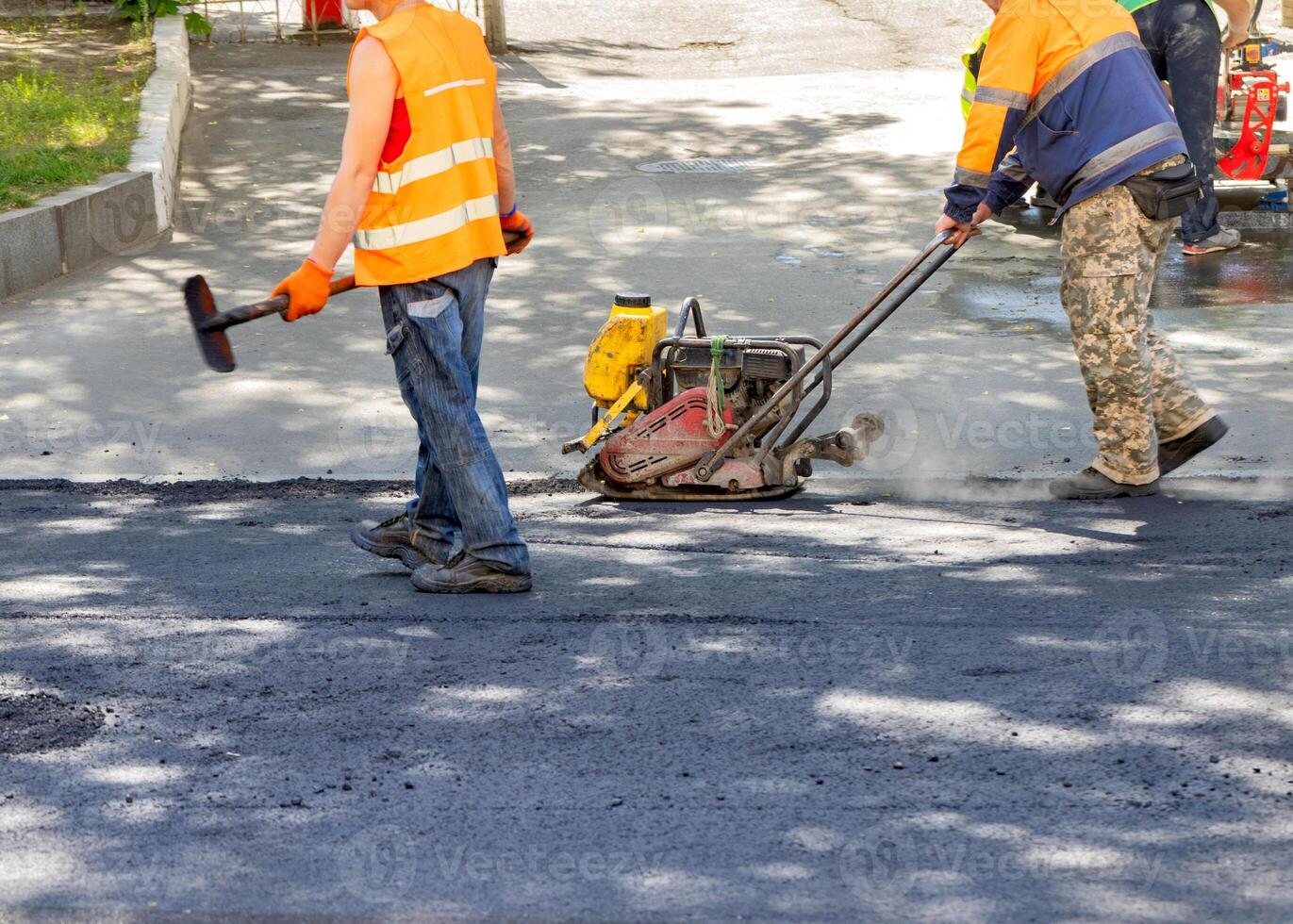 Construction workers skillfully paving a new road on a sunny day with innovative machinery photo