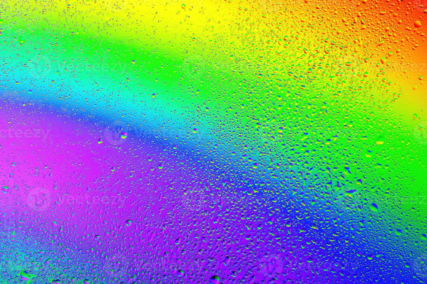 Colorful droplets create a stunning rainbow effect on a misty surface in sunlight photo