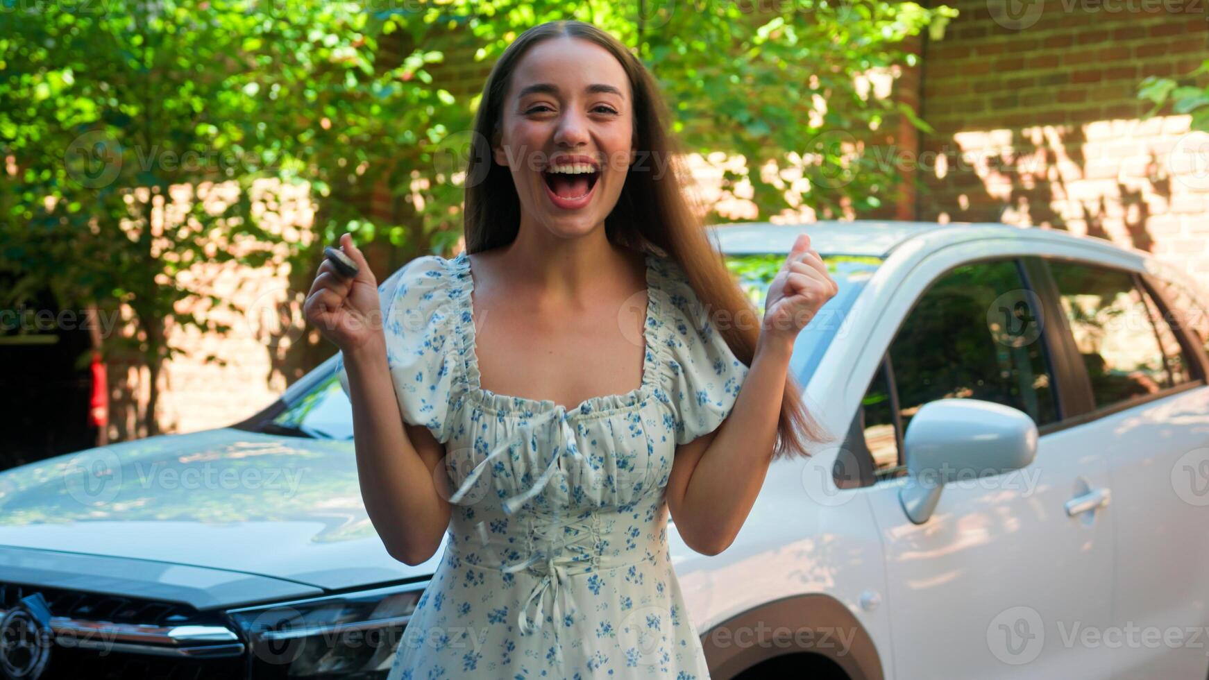 Excited pleased happy Caucasian woman female smiling girl buyer driver winner holding car keys celebrate victory win screaming yelling spinning drive transport buy auto rent automobile at city street photo