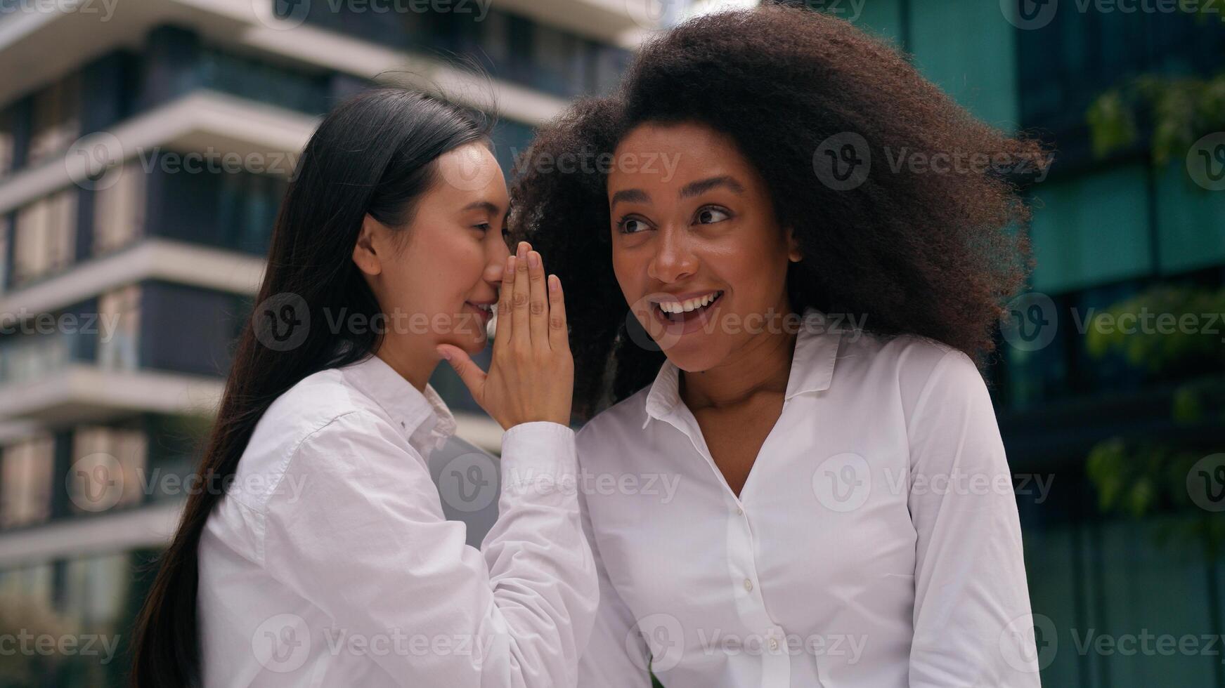 Asian Korean Chinese African American women businesswomen whisper secret gossip laughter colleagues coworkers workers girls females conversation business chatting news talk friendship fun enjoy city photo