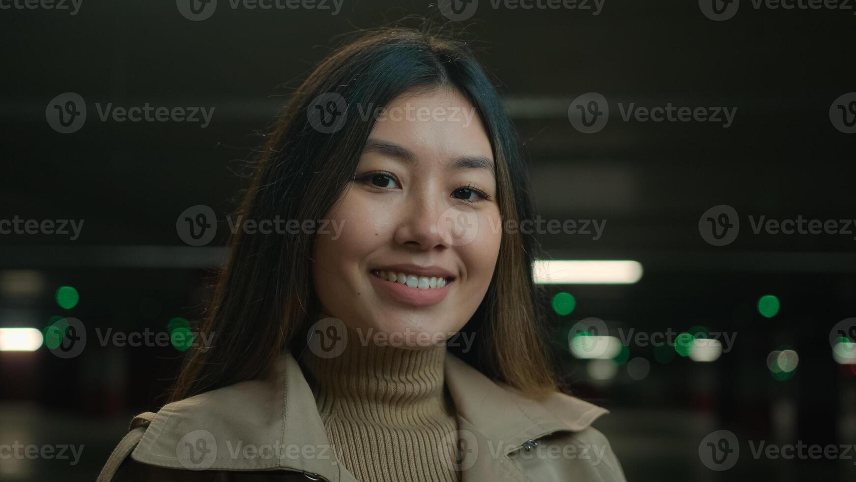 Portrait Asian chinese happy woman ethnic smiling joyful girl beautiful gorgeous korean japanese female businesswoman entrepreneur in dark car parking underground looking at camera dental toothy smile photo