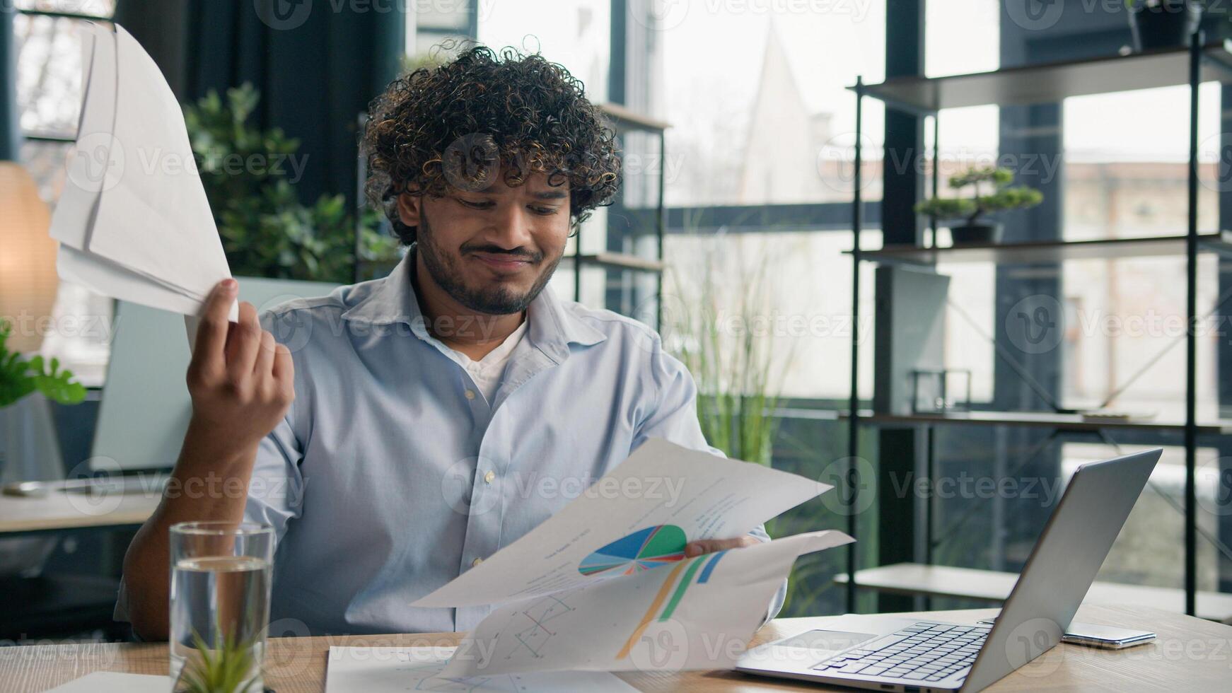 Stressed sad Arabian Indian man anxious male worker executive manager working at office check paperwork commerce on laptop upset businessman hold business papers financial mistake debt problem despair photo