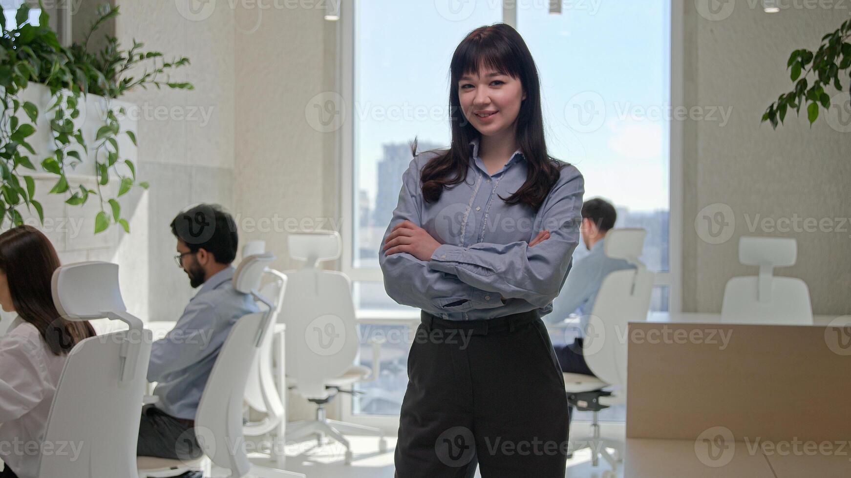Caucasian businesswoman team leader entrepreneur boss smiling happy looking at camera crossed hands pose in corporate office business company female professional CEO manage work of diverse employees photo