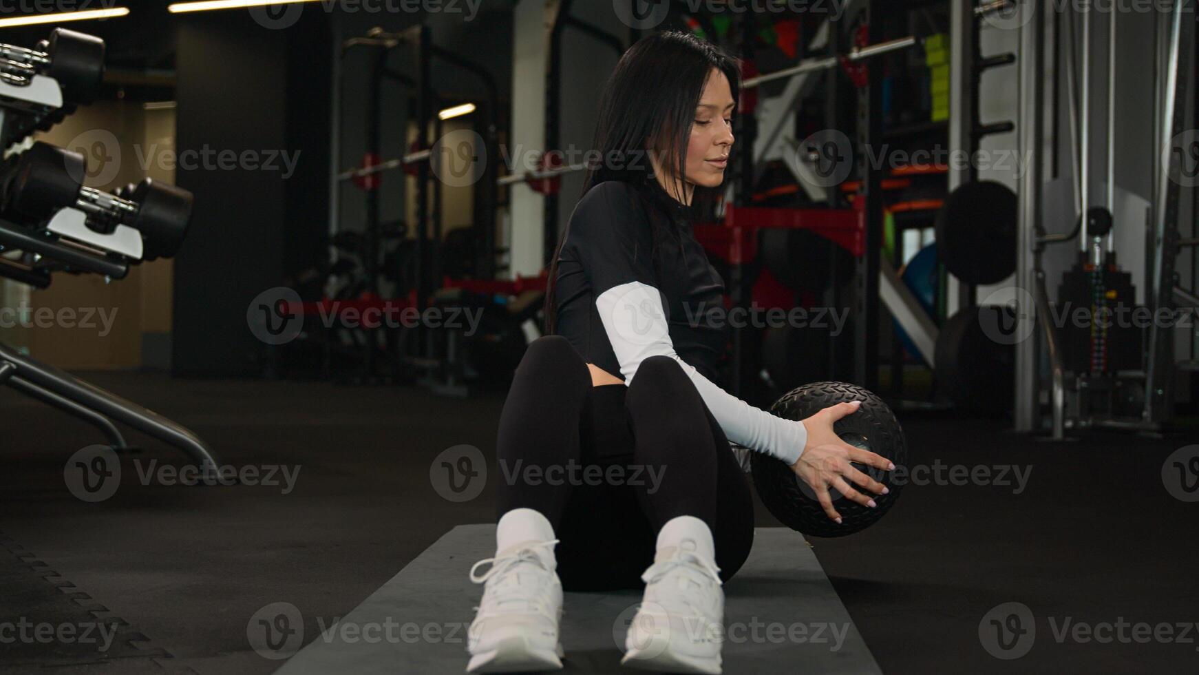 Fit muscular sportswoman make abdominal exercises with medicine ball sports equipment training on gym floor athletic Caucasian woman fitness girl athlete bodybuilder sport trainer twisting abs workout photo