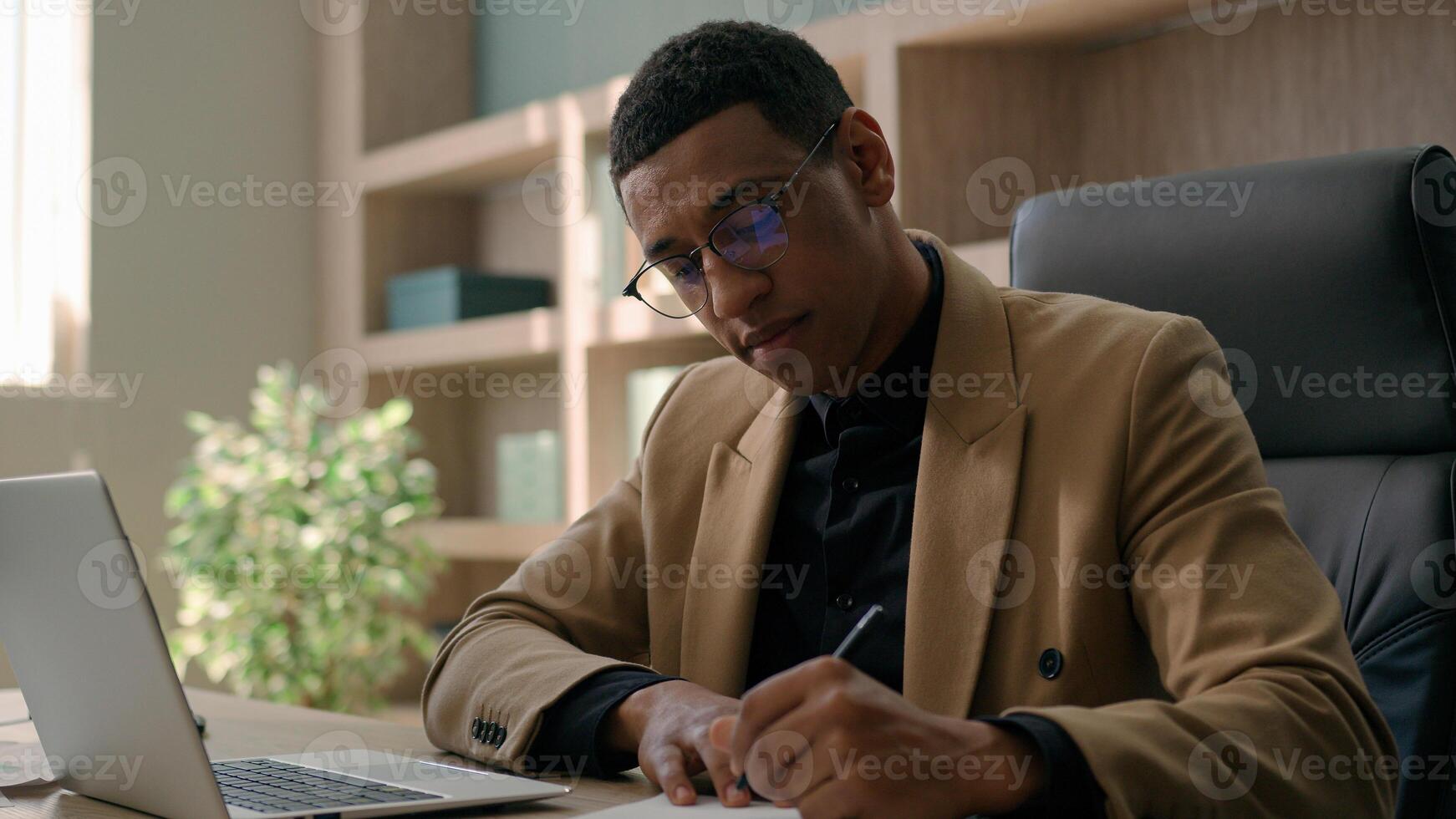 African American man accountant businessman manager analyst write notes data information writing business budget project report paperwork in office studying online with laptop educational course smile photo