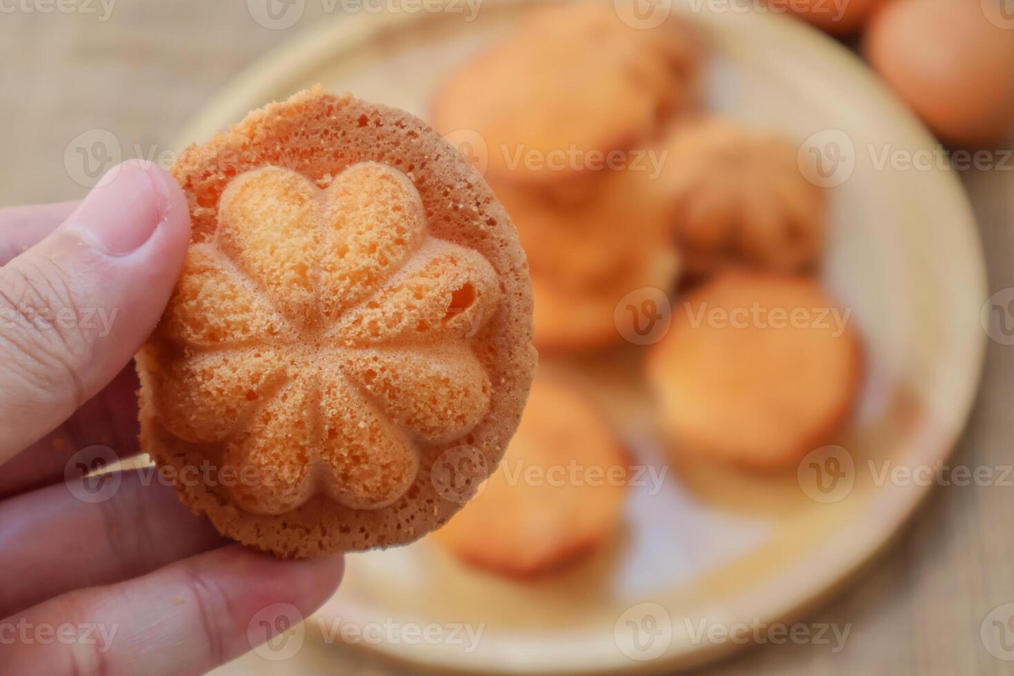 Hand holding thai egg cake with or as it is known in Thai, Khanom Khai, Made by baking, it is crispy on the outside and soft on the inside. photo