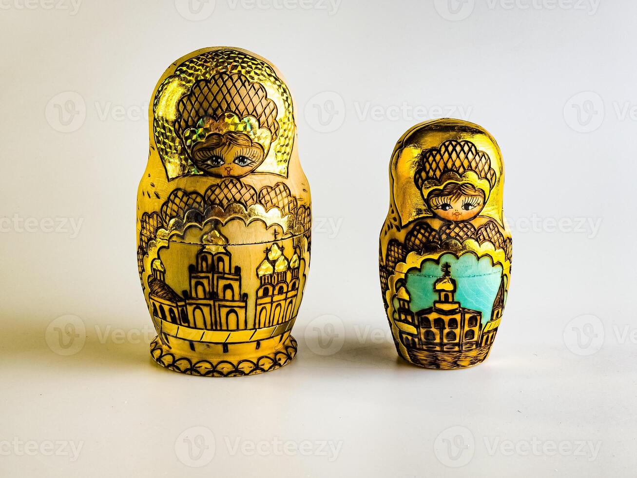 Two nesting dolls, Russian wooden doll on a white background. Gold color with Orthodox domes photo