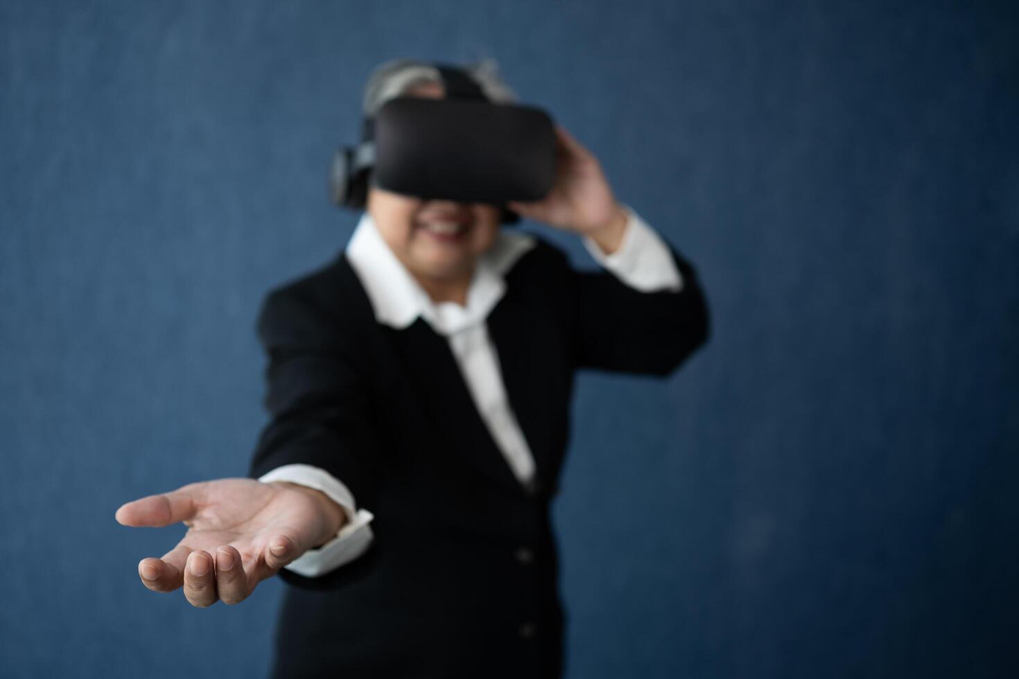 Senior Business woman wearing smart virtual glasses for conferences, VR headset glasses technology in modern offices and open the palm of the hand. Metaverse concept. photo