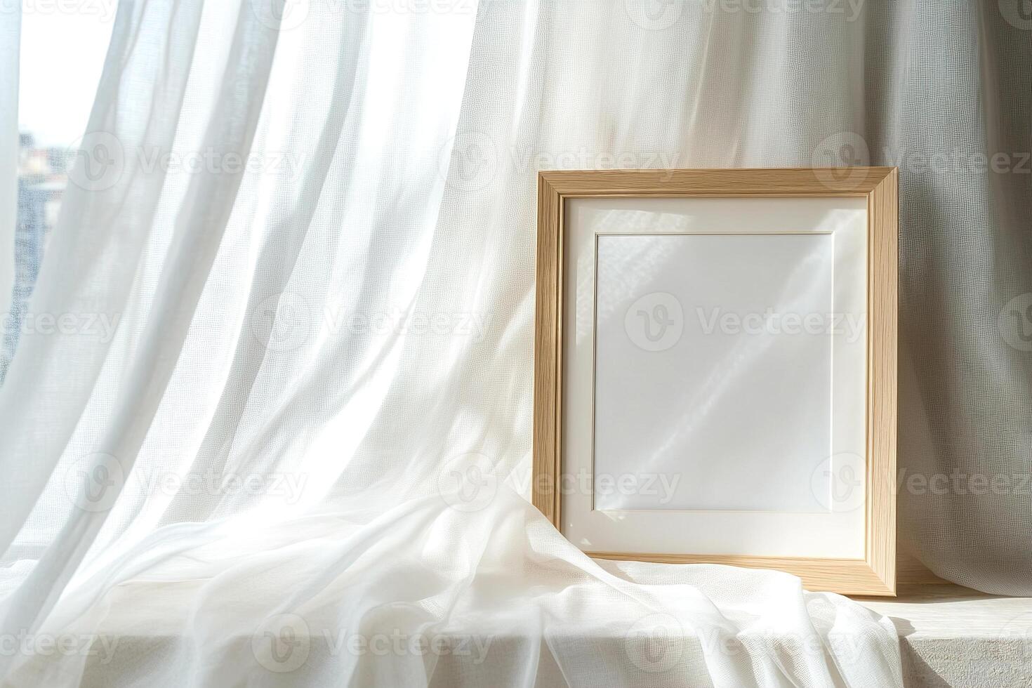 A light oak picture frame rests on a windowsill, surrounded by flowing sheer white curtains illuminated by soft natural light, creating a calm and inviting setting photo