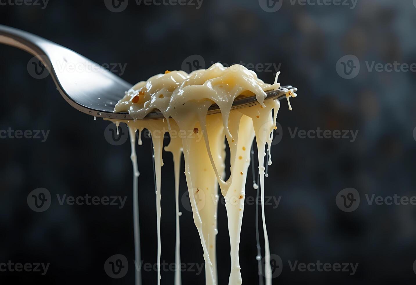 Melting Creamy Cheese Sauce Dripping From Fork Dark Background photo