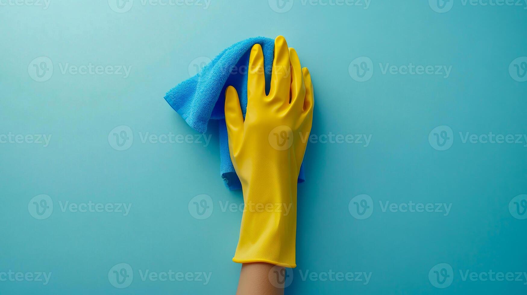 A person is cleaning a surface with a blue cloth and a yellow glove. Concept of cleanliness and orderliness photo