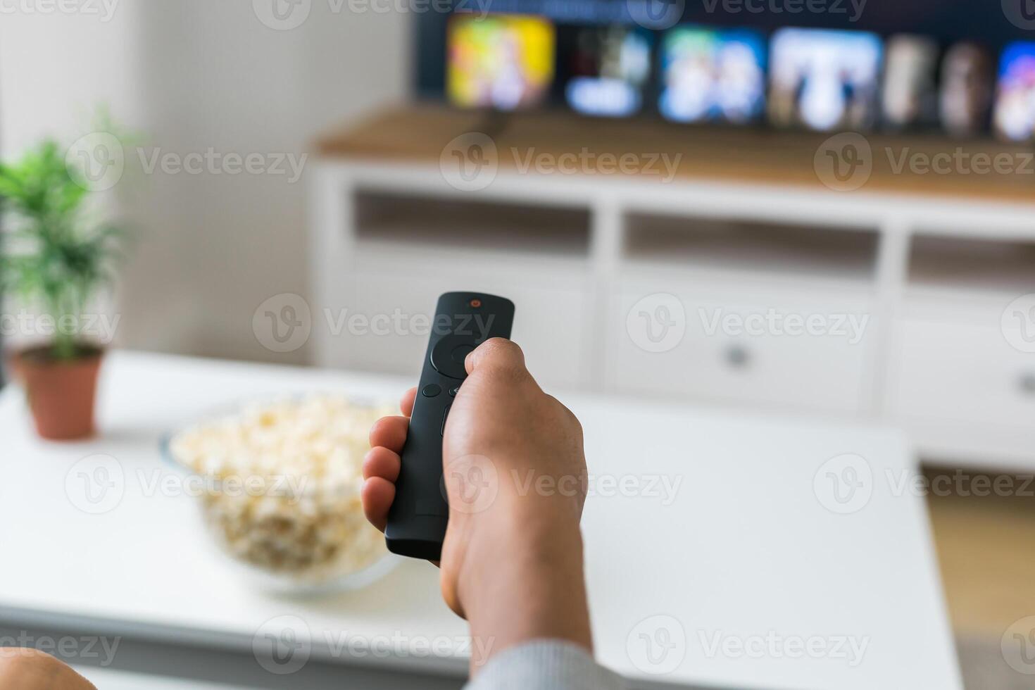 Remote control is pointed toward the television screen, control and choice of tv entertainment. TV, series and streaming service concept photo