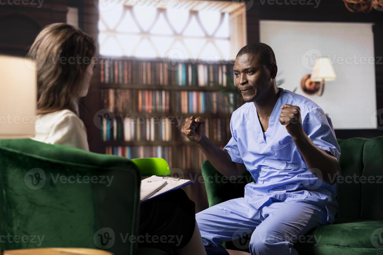 Nurse sits in serious counseling session coping with patients loss and mental health challenges. African american medical assistant working in a hospital with PTSD and trauma, powerless. photo