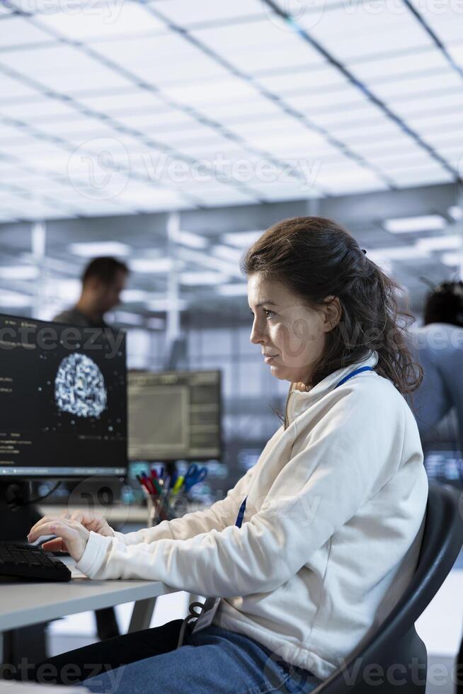 System administrator in AI server room doing system analysis, coding supercomputers. Artificial intelligence specialist working in high tech facility housing advanced storage infrastructure photo