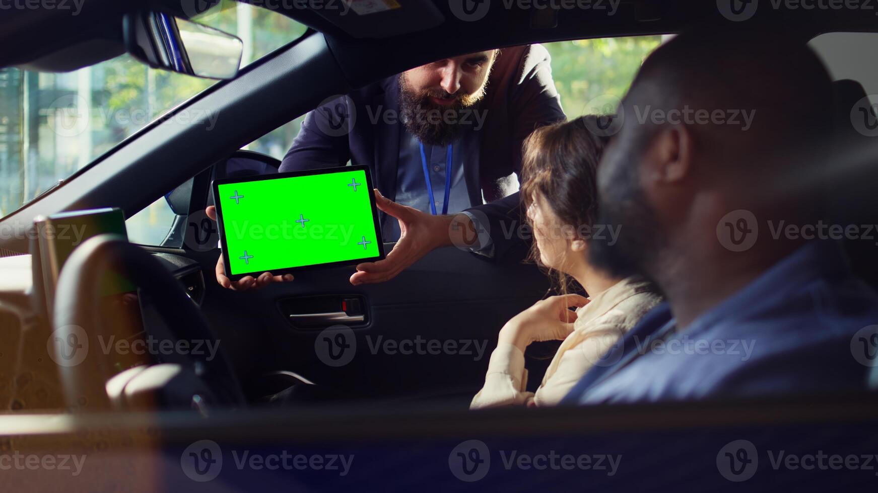 Sales executive using green screen tablet to present car addons options to clients, after finishing test drive. Showroom dealer presenting mockup device to customers driving vehicle photo
