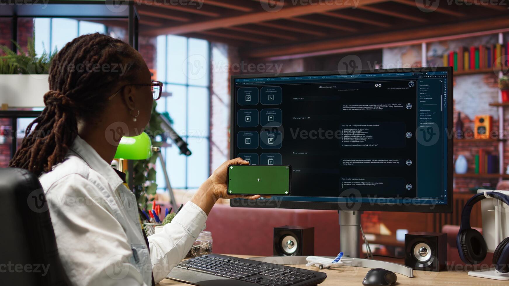 Woman seated at desk using isolated screen mobile phone to follow tutorial on AI LLM chatbot software. African american person uses mockup smartphone in apartment and GPT program on computer, camera A photo