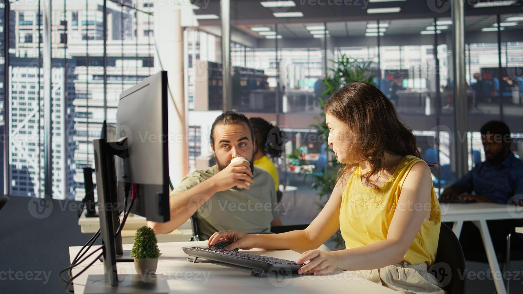 Man with paraplegia drinking coffee, checking progress done by employee doing code review to fix bugs. Worker code, being supervised by manager in wheelchair enjoying beverage, camera B photo
