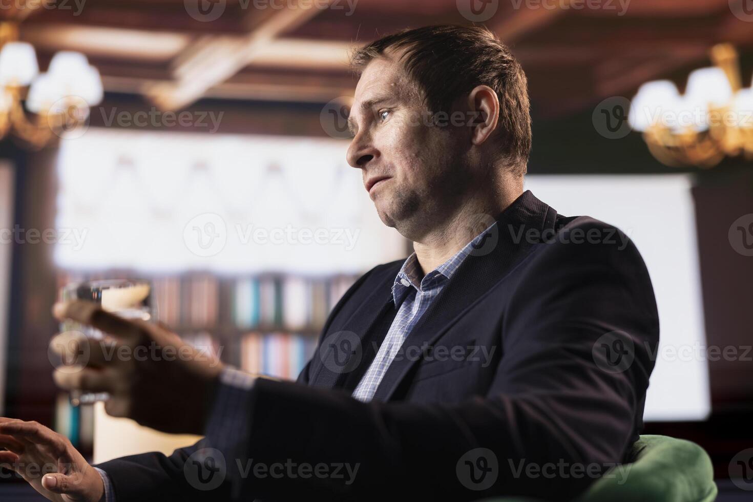 Confident business professional enjoying scotch drink during meeting in a retro style club with a friend, focusing on collaboration and building trust. Upper class negotiations between billionaires. photo