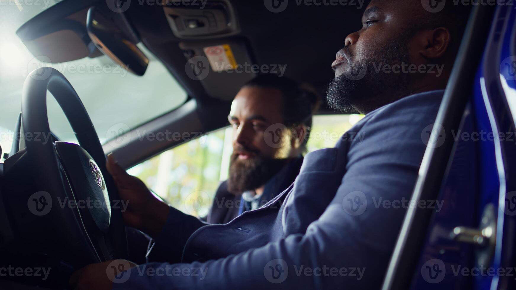 Man buying car, doing test drive to make sure everything is in good working order. African american driver examining vehicle, looking at characteristics and possible faults, camera B photo