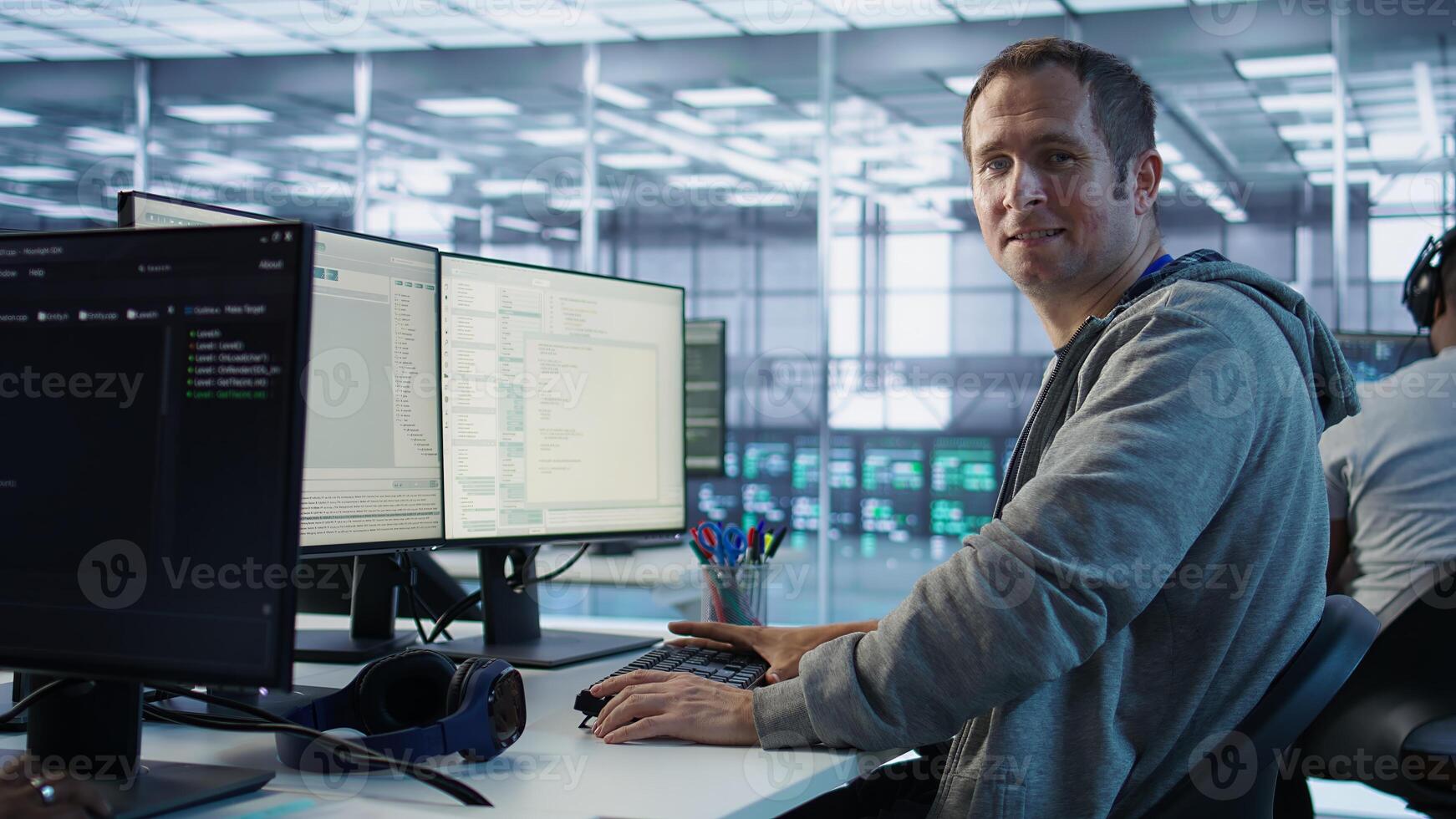 Portrait of smiling engineer inspecting server rows in data center. Happy man supervising supercomputers providing processing and memory resources for various workloads, camera B photo