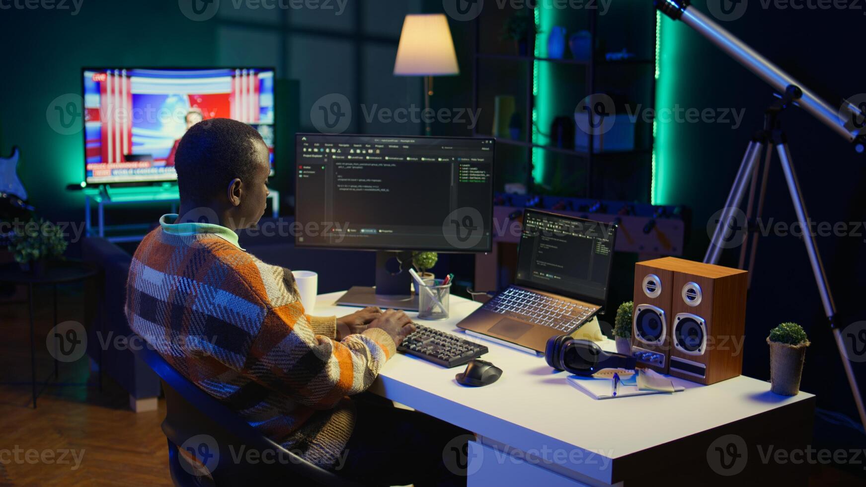 African american self employed developer in home office coding on his computer at workstation. Focused IT specialist doing contracted job from apartment, writing lines of code at desk. Camera B. photo