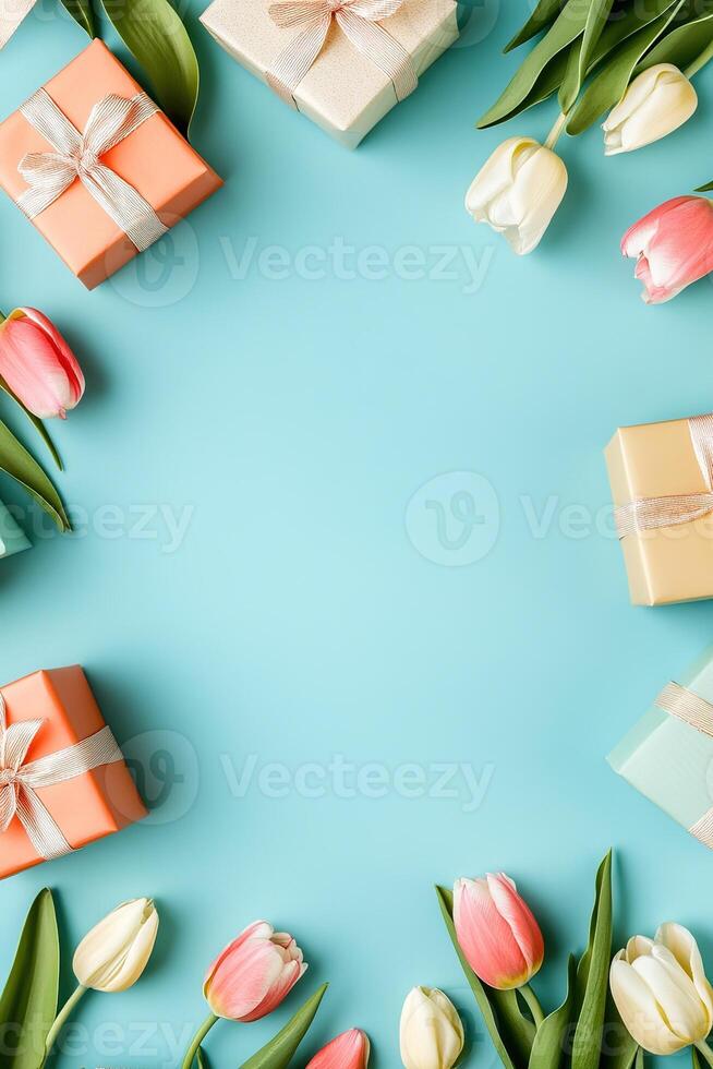 vertical floral template with tulips flowers border frame with small gift boxes on light blue background top view with copy space photo