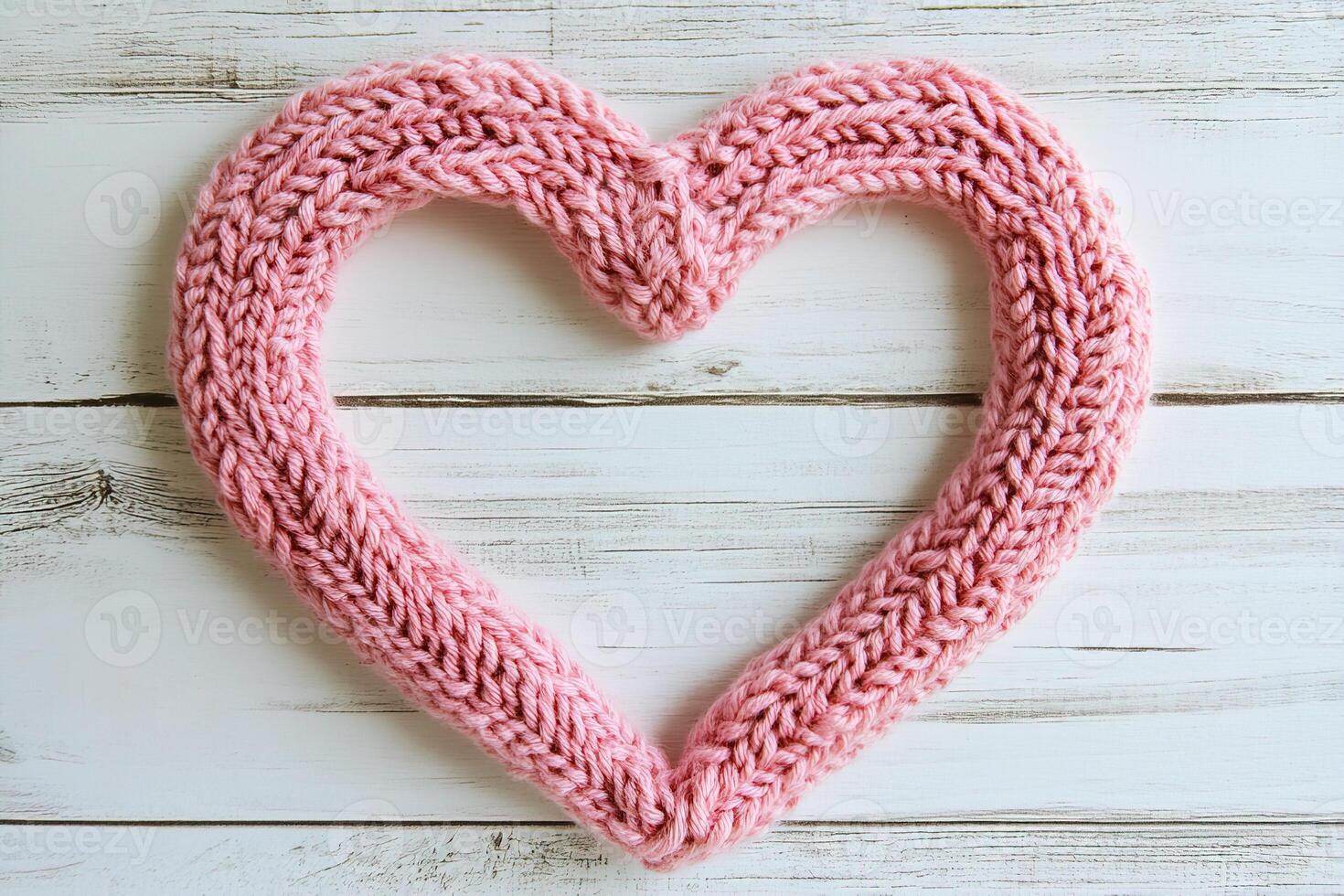 top view soft cozy pink knitted heart on white wooden planks background with copy space photo