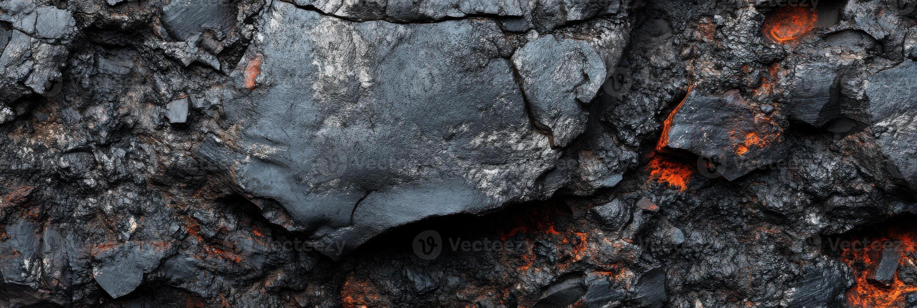 Intricate texture of black lava rock with fiery red glows in cracks photo