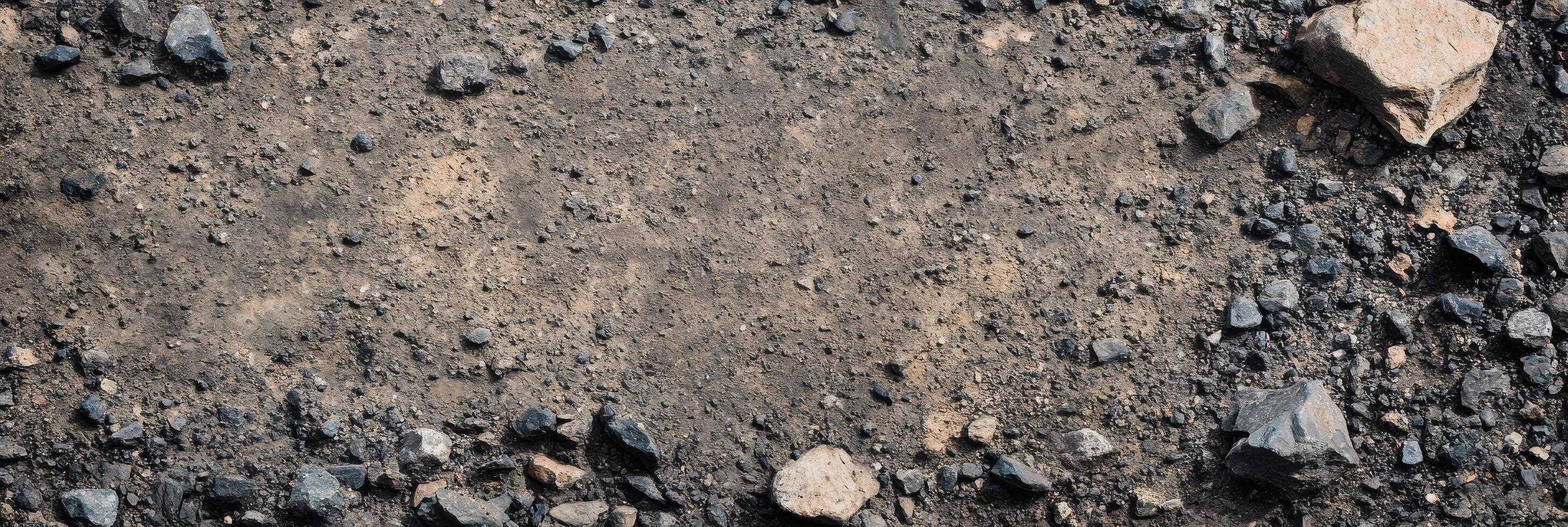 Textured gravel and soil surface with scattered rocks and pebbles reflects natural earthy landscape photo