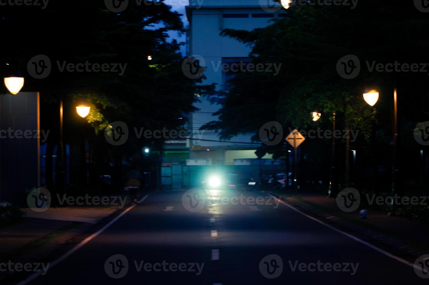 A street with a car driving down it photo