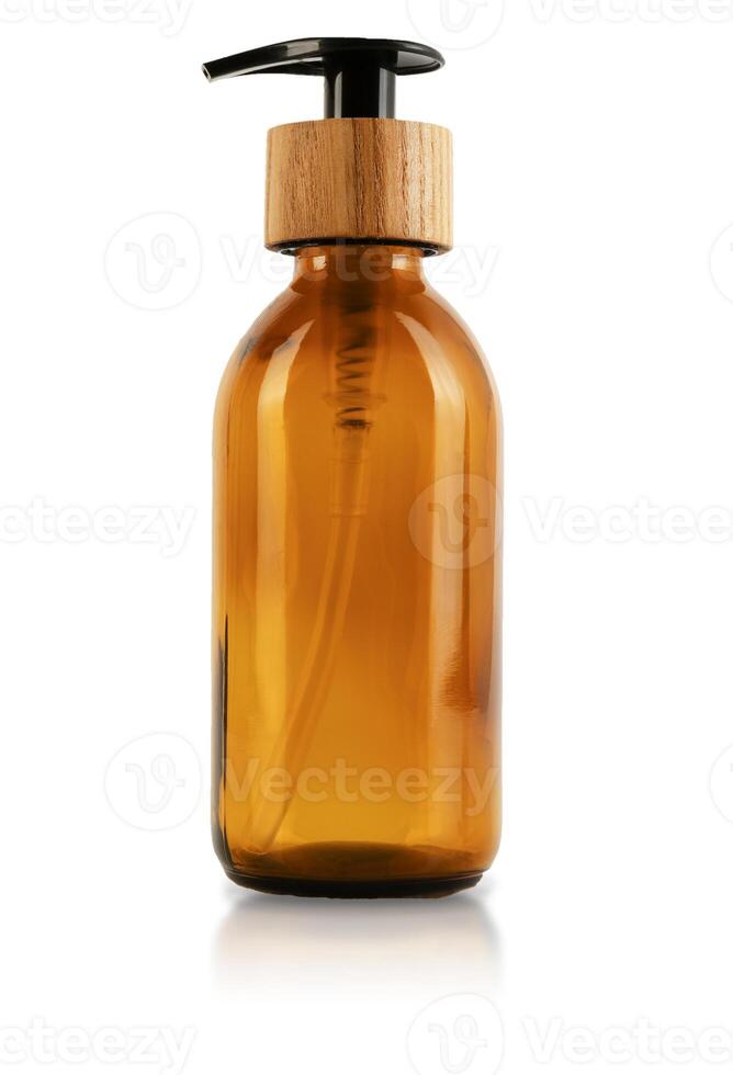 Brown glass bottle with dispenser and wooden stopper cap. Isolated on white background. Eco container for cosmetics. A container with a straw inside and a button for a pump for gel, lotion or shampoo photo