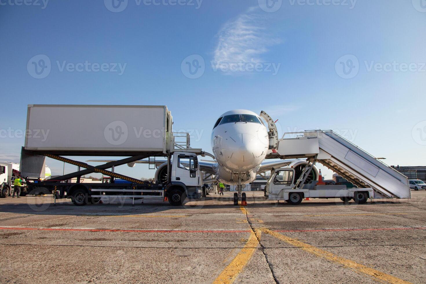 Boarding passengers on the plane. Boarding bridge. The plane lands at the international airport. Loading luggage. White airplane. Terminal Runway. Copy space photo