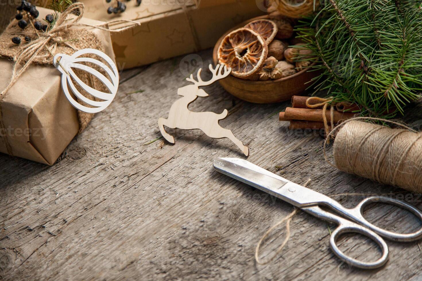 Gift wrapping for Christmas and New Year. Wooden background with place for text. Gift in craft wrapping paper. Prepare for the holiday. Copy space. photo