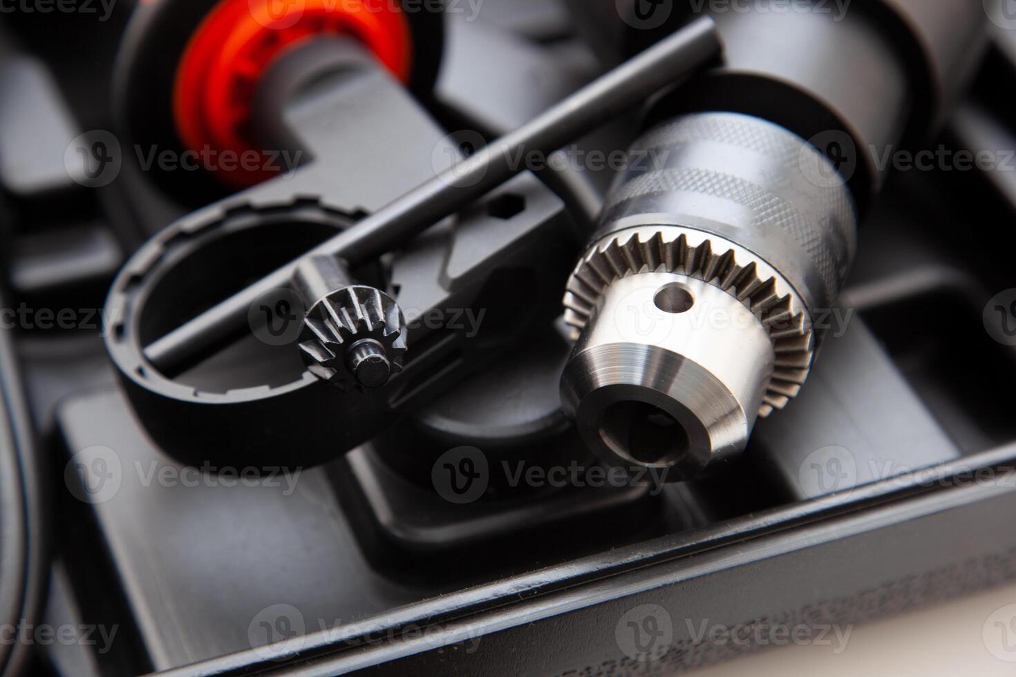 Electric drill in a suitcase. Keyless chuck. Gear teeth. Close-up tool. Metal details. Worker mechanics and tools photo