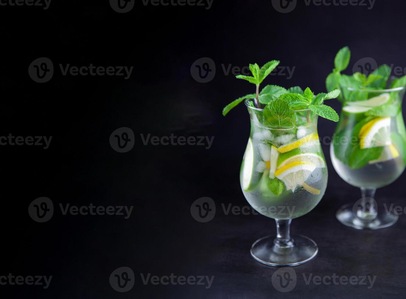 Mojito on a black background. Summer soft drinks with copy space. Lemon, lime, mint, ice, water. Bar menu photo