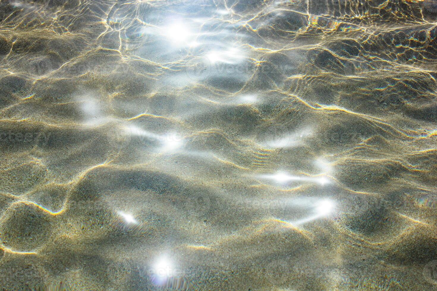 Beautiful shiny sea water surface with sunlight reflections and shadow on bottom. photo