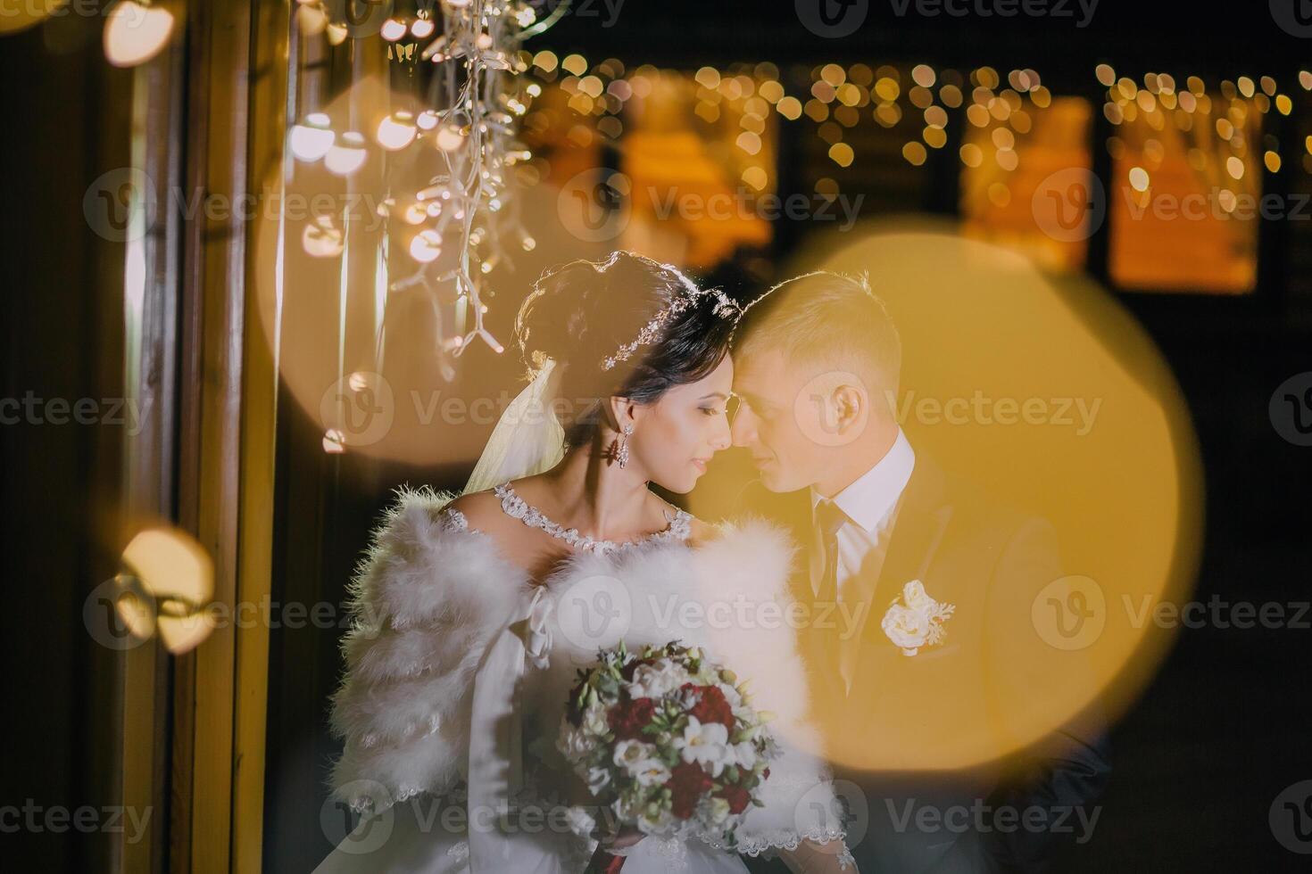 bride and groom are kissing in front of a window photo