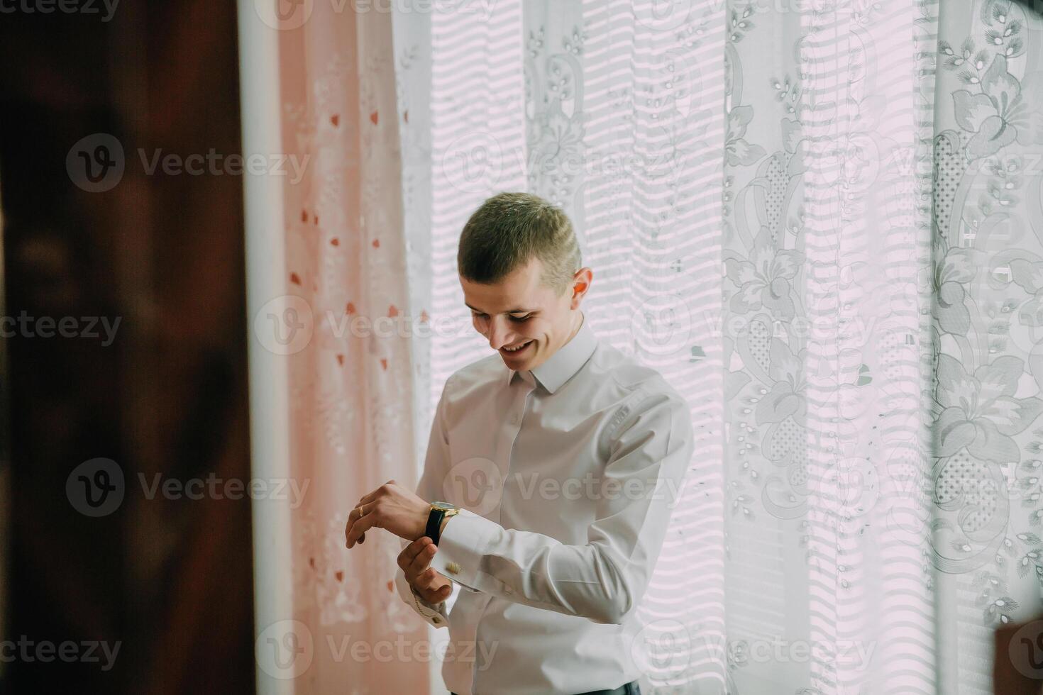 A man is wearing a white shirt and a watch photo