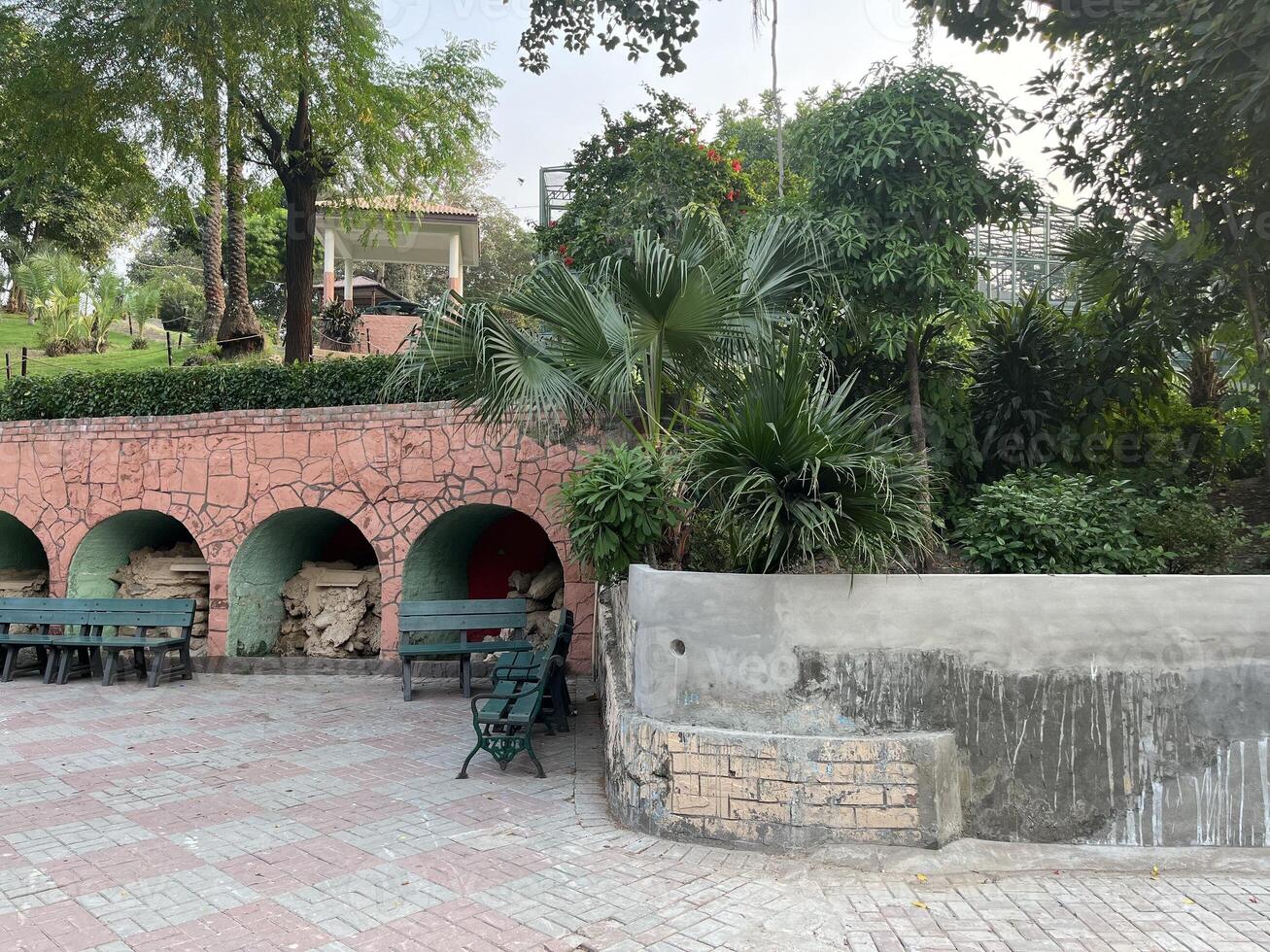 a small park with benches and a fountain in Lahore on 10-10-2024 photo