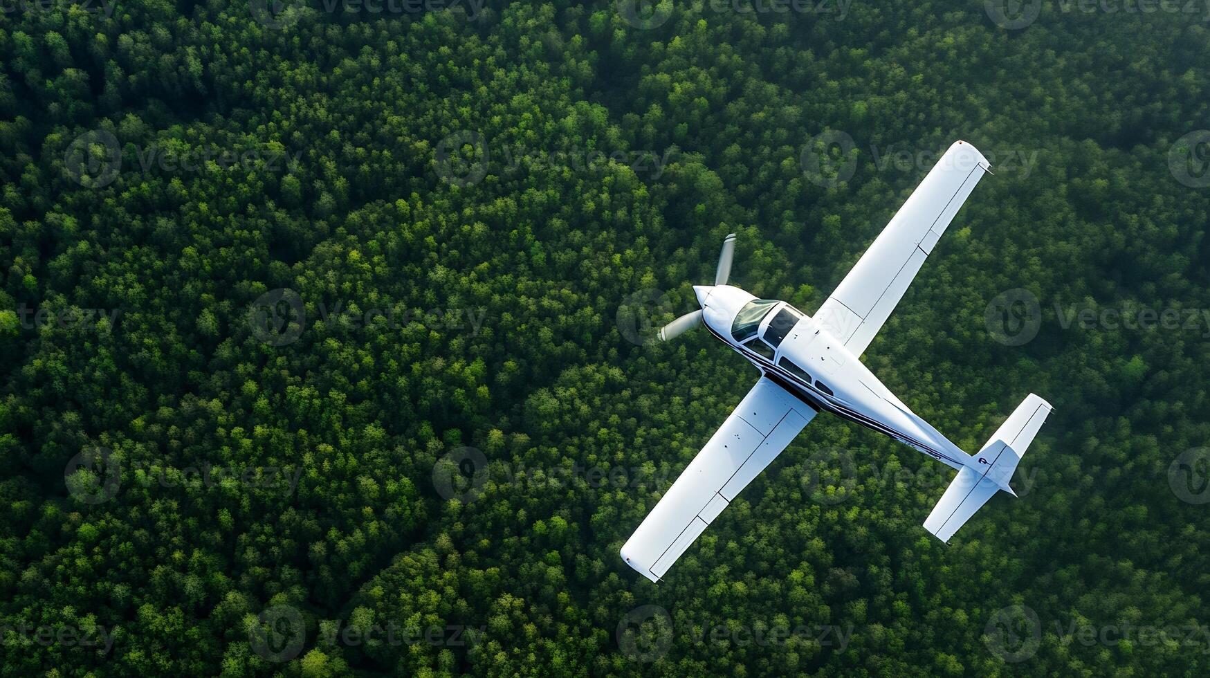 Single Engine Plane Flying Over Dense Green Forest on Clear Day with Blue Sky photo