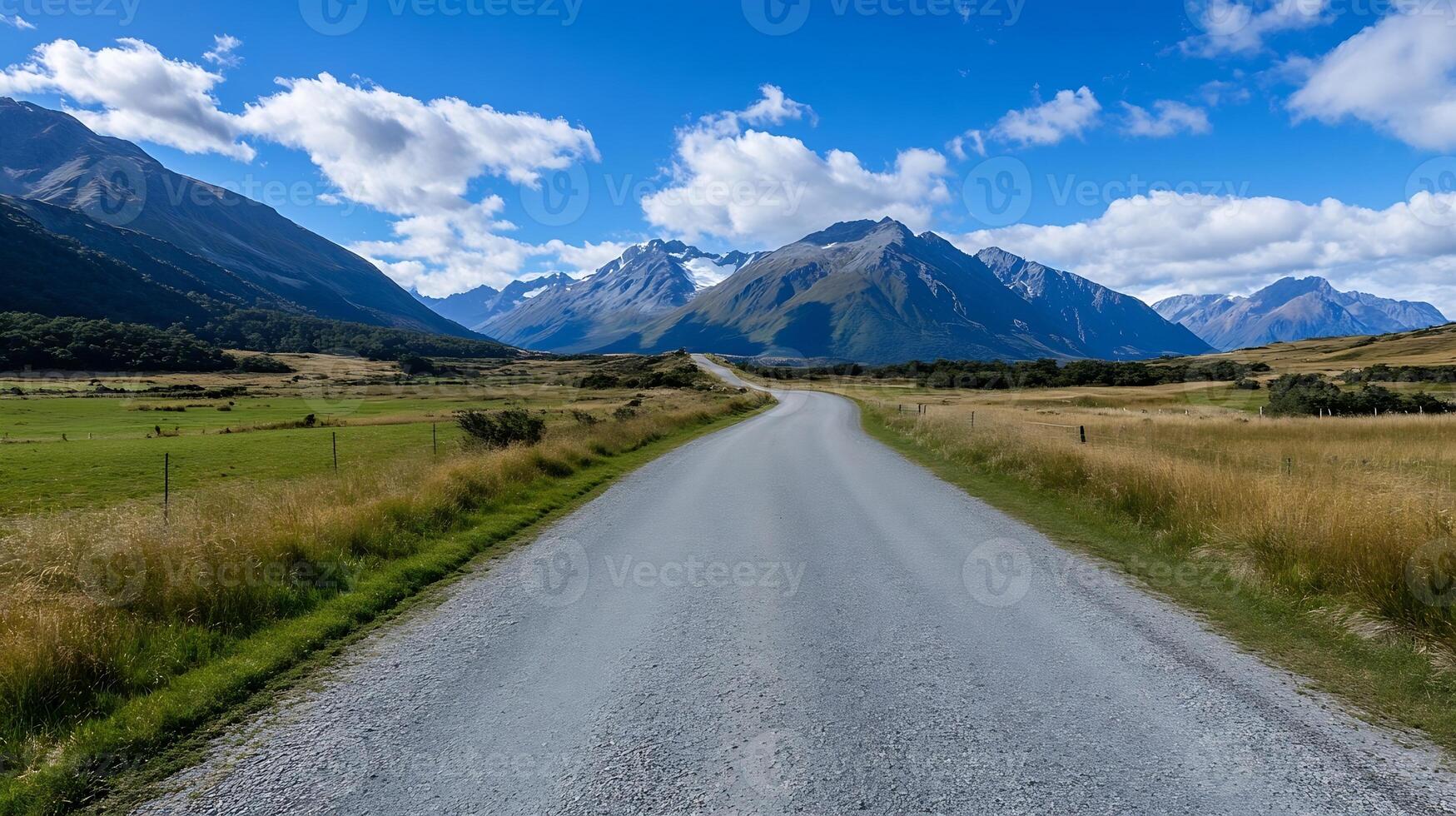 Inspiring Scenic Road Leading into Majestic Mountain Range under a Clear Blue Sky photo