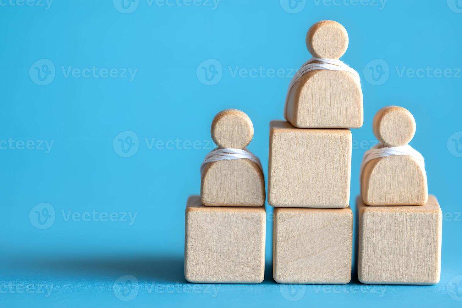 Wooden figures arranged on blocks represent hierarchy photo