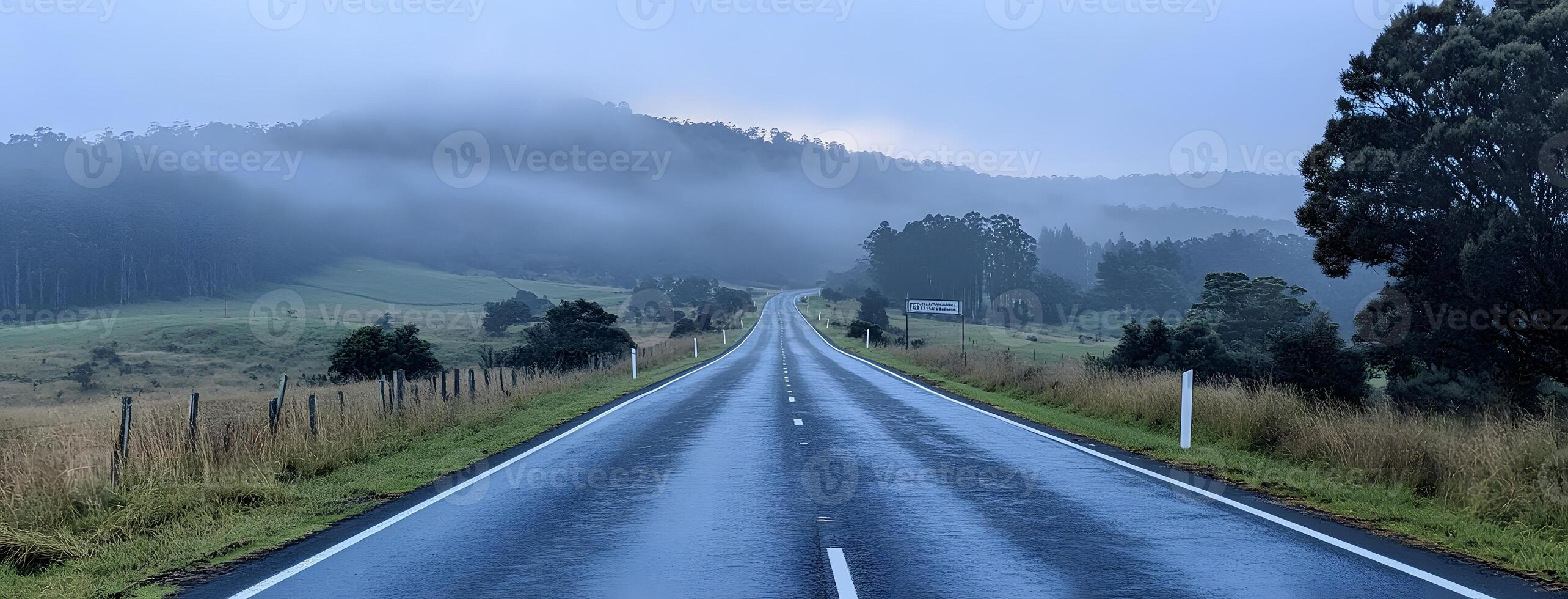 Misty Mountain Road Winding Through Lush Green Fields photo