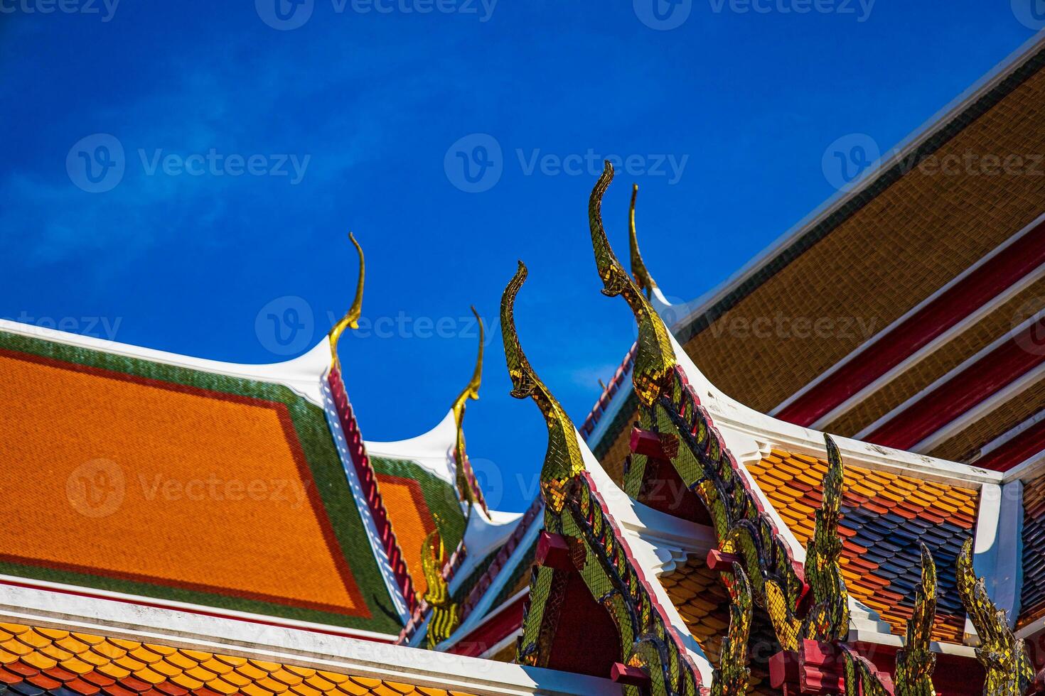 The Thai temple roof at Wat pho with blue sky, Bangkok, Thailand. photo