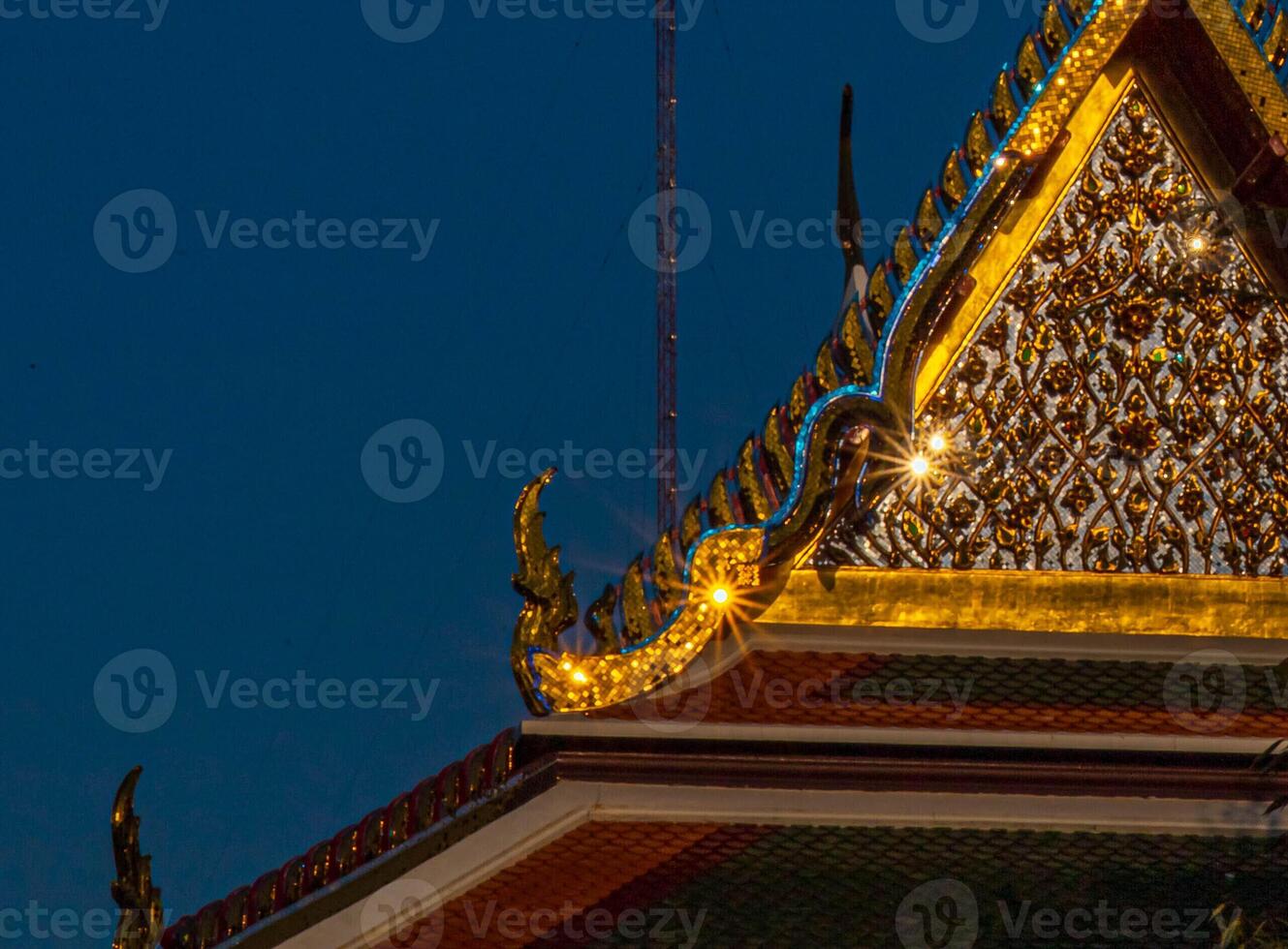 The contrast between blue and golden color with sun rays on the temple's roof. photo