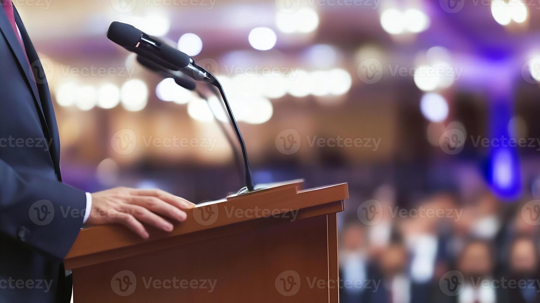 Orator Delivering Speech at a Podium in Front of Blurred Audience photo