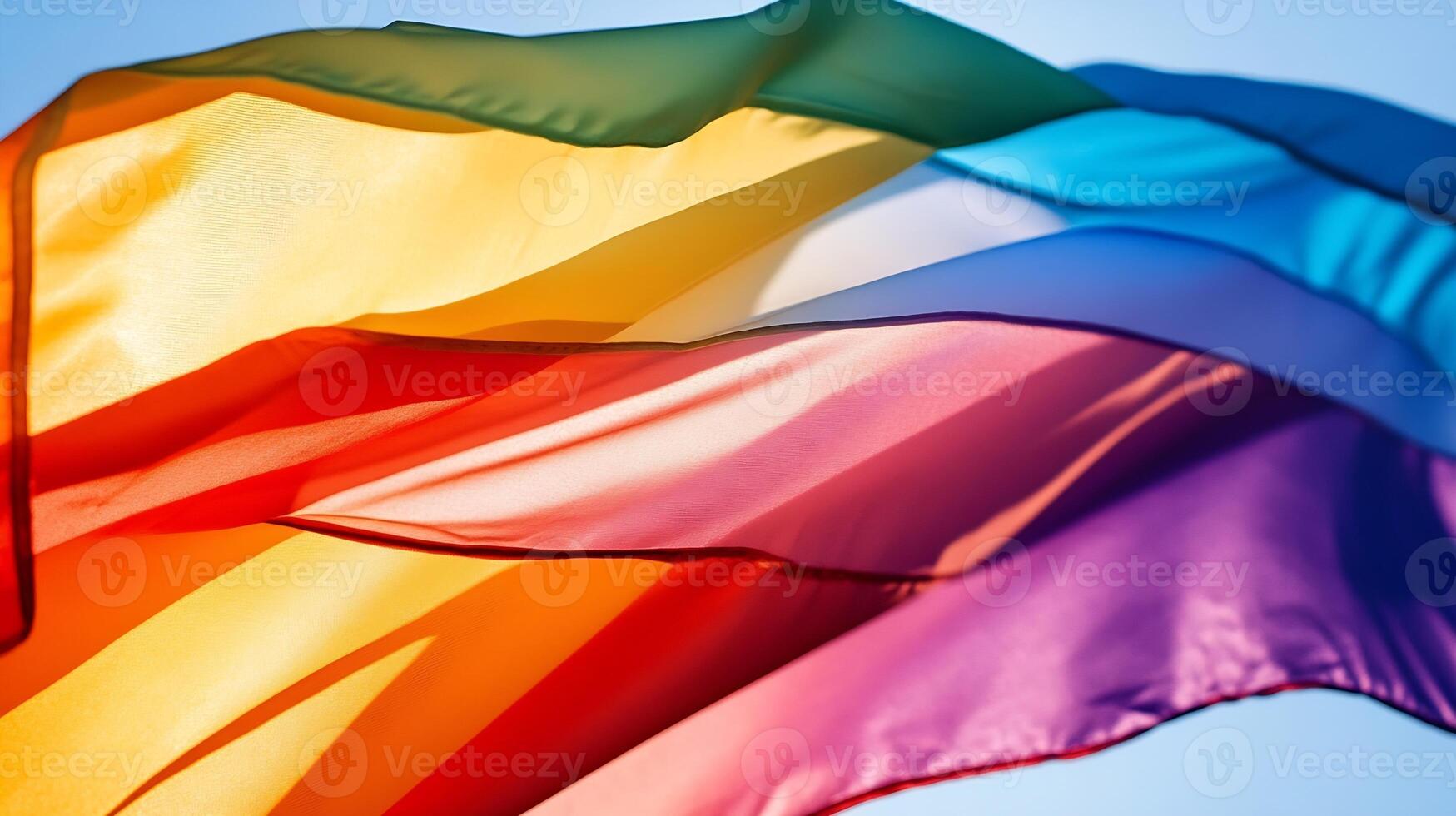 Vibrant Multicolored Pride Flag Waving Against a Clear Blue Sky photo