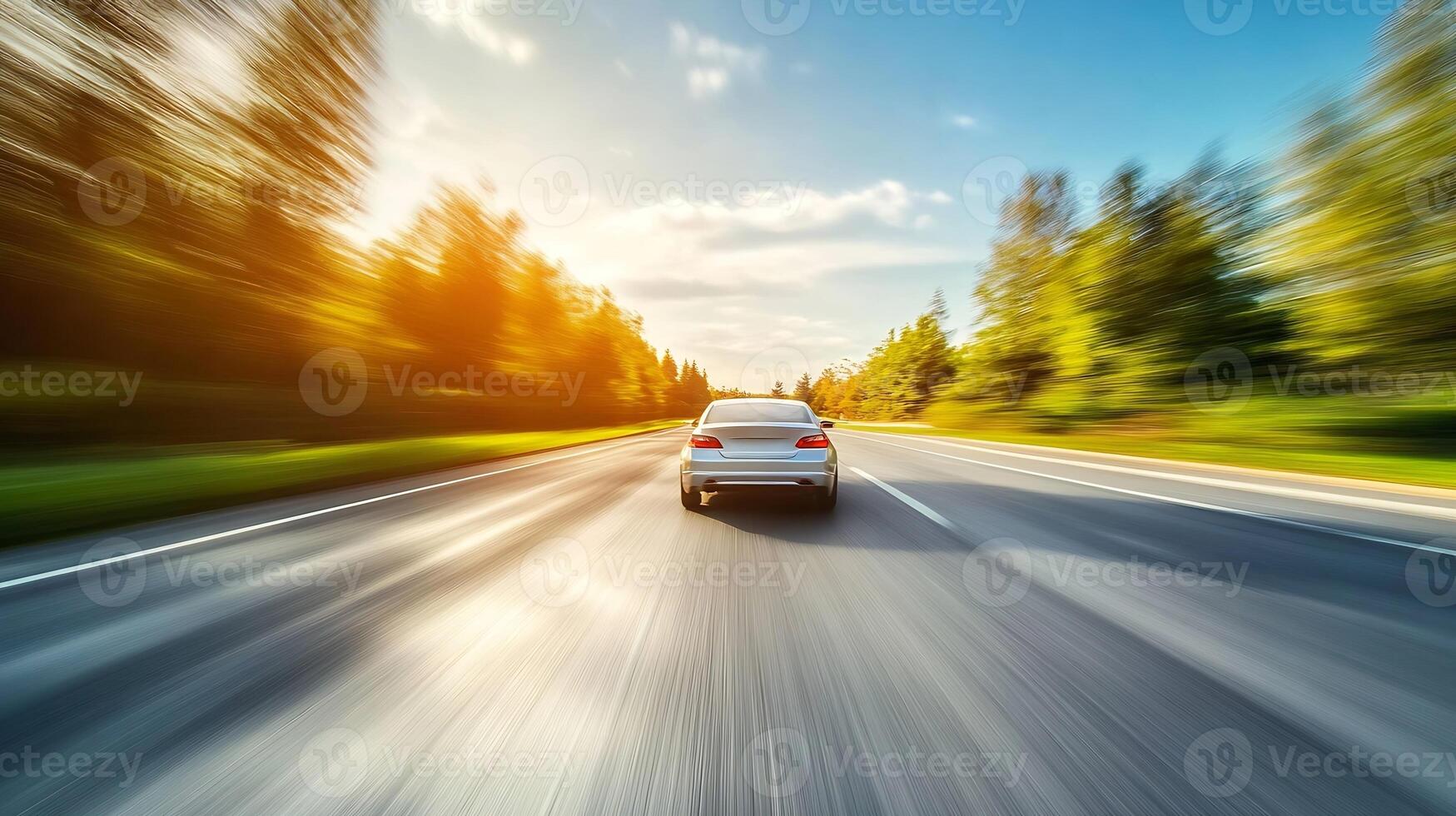 Speeding white car on sunlit rural highway surrounded by lush green forest photo